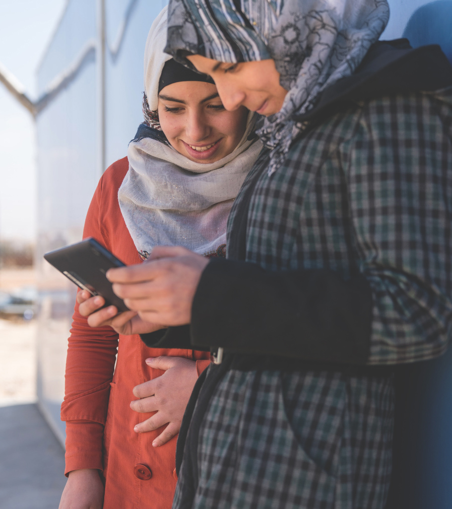 On 19 January 2017 in Jordan, two adolescent girls use a cellphone outside a solar kiosk in the Za’atari camp for Syrian refugees, in Mafraq Governorate, near the Syrian border. The kiosk – supported by worldwide solar energy provider SOLARKIOSK AG; systems and services provider SES Techcom Services (an affiliate of global satellite operator SES); and UNICEF – provides internet connectivity and is equipped with tablets and computers. It also serves as a charging station for cellphones and other electronics equipment, and as an e-learning centre for children and youths in the camp. More than 80,000 people currently shelter in the Za’atari camp. Over half of them are children.

Primero is an open source technology platform enabling governments, aid agencies and social service workers to provide life-saving services and conduct case management for most vulnerable children was launched by key players in the humanitarian sector including UNFPA, UNHCR, the International Medical Corps, International Rescue Committee, and UNICEF in February 2017. Primero was created as a case management tool that enables social workers in the field to manage children displaced by conflict and provide them with a means to access basic services including family reunification in their host communities. In response to humanitarian crisis Primero is preparing for scale in humanitarian settings in host communities Lebanon, Jordan and the Kakuma refugee camp in Kenya. Primero is also being adapted and deployed for the case management of most vulnerable children in non-humanitarian contexts, more broadly. It is a highly configurable web application and mobile app that can run on a laptop, a privately-hosted server, or in a managed cloud environment enabling case workers on the move in refugee camps and in remote locations. As an open source tool Primero’s code is publically available and encourages further application for children in communities displaced by conflict and crisis, and in